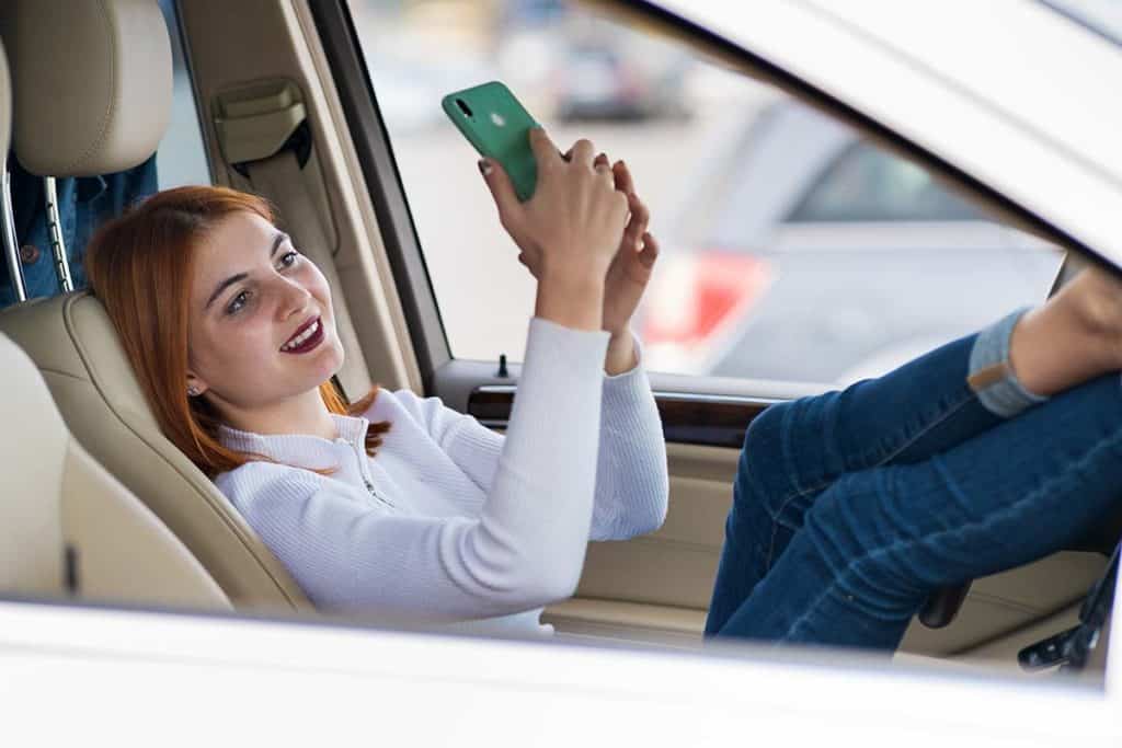 Woman driver taking selfies with her mobile phone